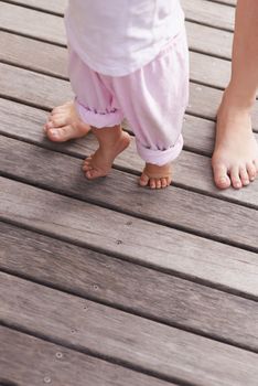 Learning to walk. Cropped closeup image of a mother helping her baby to take her first steps