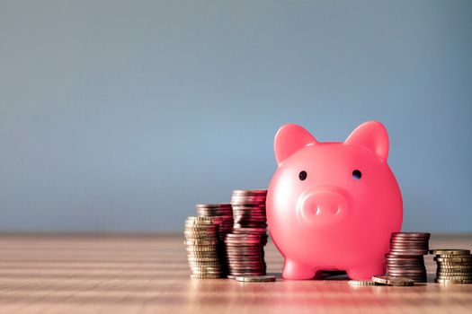 Piggy bank pink colour with money stack step up growing growth saving money, Concept financial business investment. Copy space for your text gray background close up