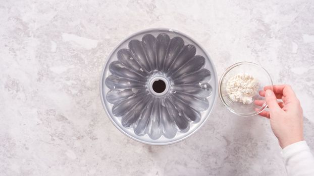 Flat lay. Step by step. Greasing bundt cake pan with vegetable shortening and sprinkling with white flour.