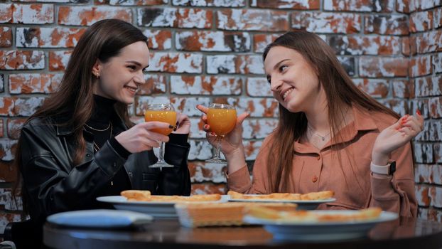 Young girls eat in a cafe and talk