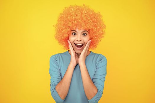 Funny kid in curly redhead wig. Time to have fun. Teen girl with orange hair, being a clown. Excited teenager, glad amazed and overjoyed emotions