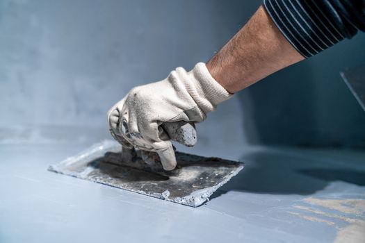 spreading the insulation on the concrete with a trowel.