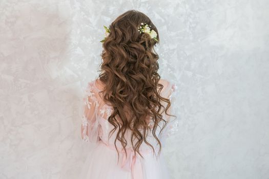 A girl with spinners demonstrates a wedding hairstyle