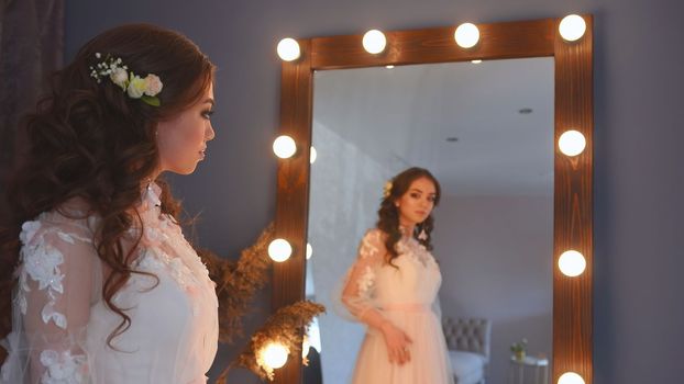 Girl model poses in a white dress