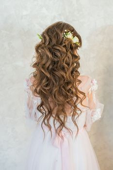 A girl with spinners demonstrates a wedding hairstyle