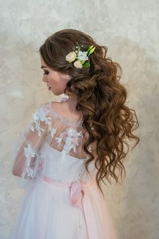 A girl with spinners demonstrates a wedding hairstyle