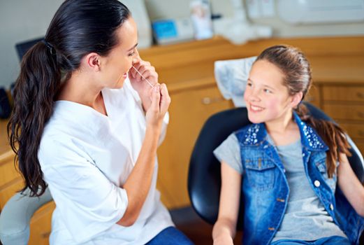 Your teeth look very healthy. a female dentist and child in a dentist office