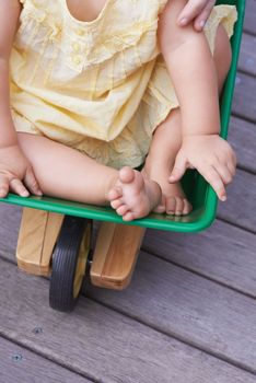 Push me faster, Mom. Cropped image of a baby girl being pushed in a toy wagon