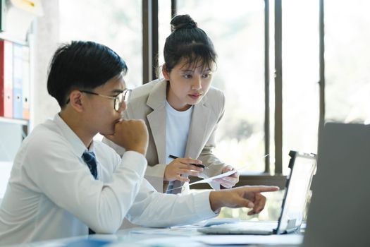 Businesspeople or colleagues are working together on investment project, discussing, sharing ideas, planning, and analyzing the business strategy and finance using laptop computer.