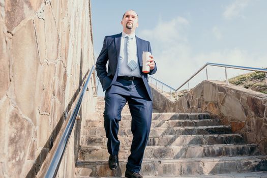 Business executive with briefcase going down the stairs.