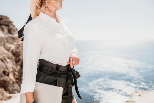 Happy girl doing yoga with laptop working at the beach. beautiful and calm business woman sitting with a laptop in a summer cafe in the lotus position meditating and relaxing. freelance girl remote work beach paradise