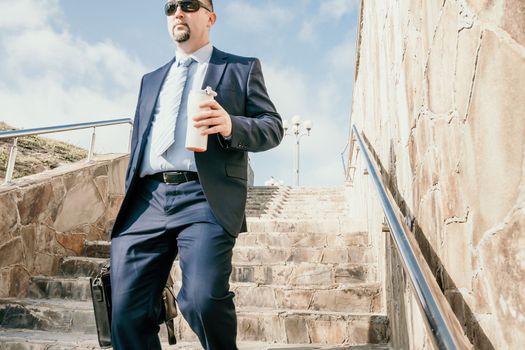 Business executive with briefcase going down the stairs.