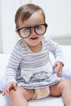 Shes destined for great things. A cute little baby girl wearing over-sized spectacles