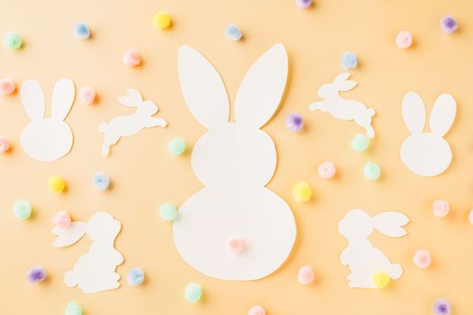 Easter Day Concept. Top view handmade white paper rabbit cutting isolated on pastel background with copy space for your text, Happy Easter Bunny holiday