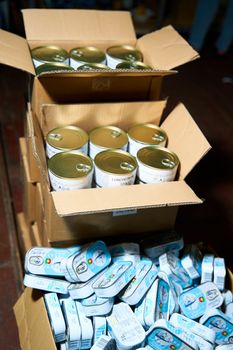 Humanitarian aid warehouse in ukrainian volunteer centre. Cardboard boxes with canned fish and meat. Dnipro, Ukraine - 06.28.2022