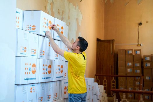 Volunteer sorting out boxes with humanitarian aid. Dnipro, Ukraine - 06.28.2022