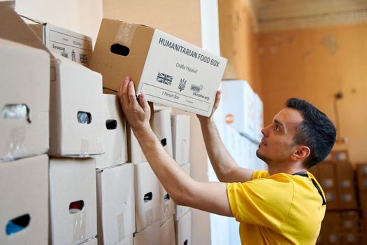 Ukrainan volunteer sorting boxes with humanitarian aid to Ukraine from UK. Dnipro, Ukraine - 06.28.2022