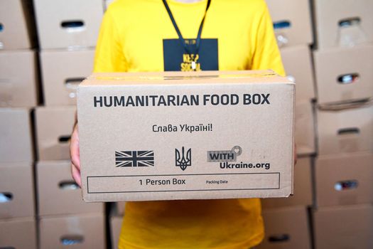 Ukrainan volunteer sorting boxes with humanitarian aid to Ukraine from UK. Dnipro, Ukraine - 06.28.2022