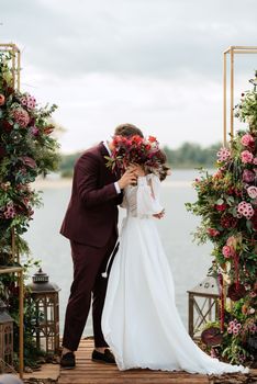 wedding ceremony of the newlyweds on the pier near the restaurant