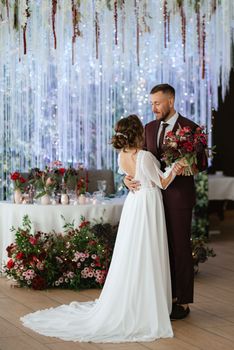 portrait of a young couple of newlyweds in wedding looks in marsala color