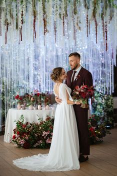 portrait of a young couple of newlyweds in wedding looks in marsala color