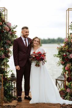 wedding ceremony of the newlyweds on the pier near the restaurant