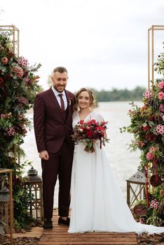 wedding ceremony of the newlyweds on the pier near the restaurant