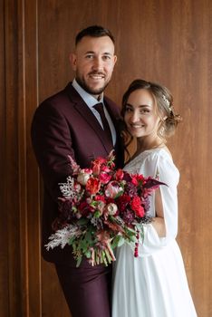 portrait of a young couple of newlyweds in wedding looks in marsala color