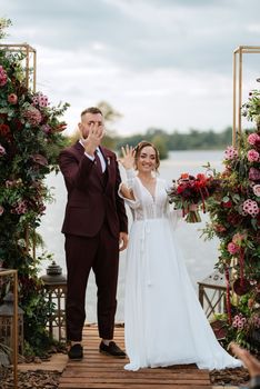 wedding ceremony of the newlyweds on the pier near the restaurant