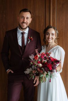 portrait of a young couple of newlyweds in wedding looks in marsala color