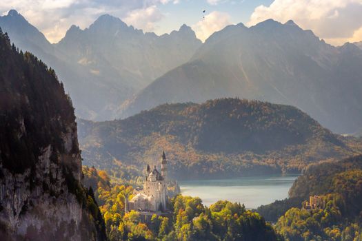 Neuschwanstein and Lake reflection in Bavarian alps at golden autumn, Karwendel mountains, Bavaria, Germany border with Austria