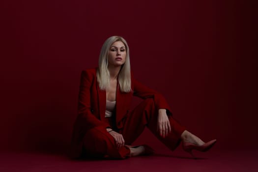 Portrait of a blonde woman in red dress on a red background