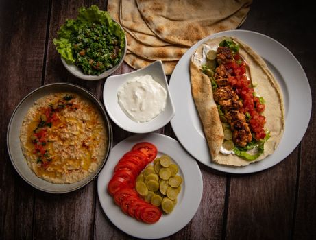 Lebanese recipe of chich taouk, garlic cream, toum, in a Lebanese bread, tabbouleh and chickpea puree, hummus High quality photo