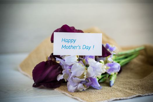 bouquet of beautiful blooming iris flowers on a light wooden background
