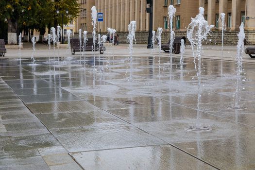 Slow splashes of a modern fountain spouting from underground