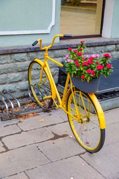 Flowerbed design in the form of a yellow bicycle in the parking lot