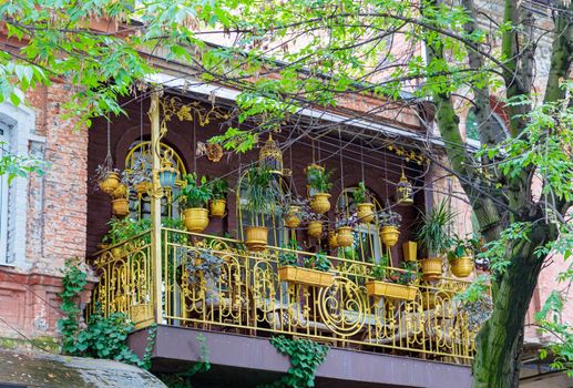 Beautiful balcony with hanging flower pots, comfortable chairs and a table for gatherings