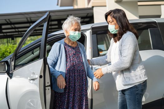 Caregiver help and support asian senior or elderly old lady woman patient walk with walker prepare get to her car, healthy strong medical concept.