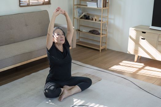 Portrait of Mature Woman doing stretching yoga side bend. exercise and stretching concept.