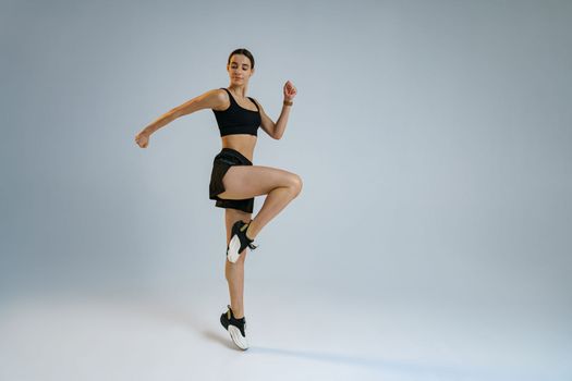 Athletic active woman jumping on studio background . Dynamic movement