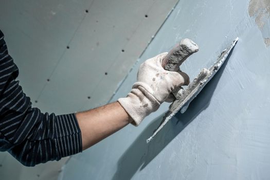 manual work with a trowel for waterproofing the wall.