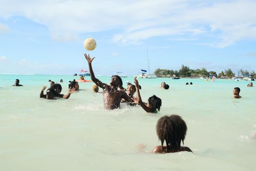 December 8, 2019 Mauritius Island, locals swim in the Indian Ocean and play with a ball.