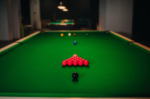 placing snooker balls on a green billiard table.