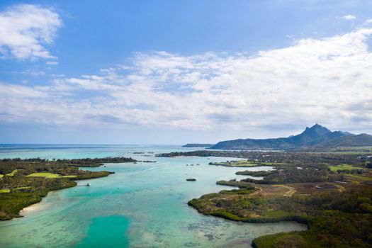 Aerial picture of the east coast of Mauritius Island. Beautiful lagoon of Mauritius Island shot from above. Boat sailing in turquoise lagoon.