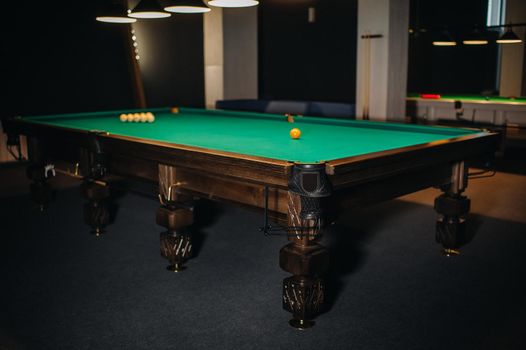 Billiard table with green surface and balls in the billiard club