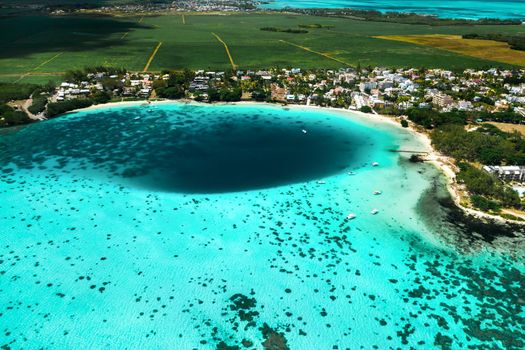 Top view of the Blue Bay lagoon of Mauritius. A boat floats on a turquoise lagoon.