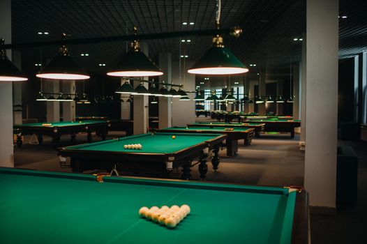 Billiard table with green surface and balls in the billiard club