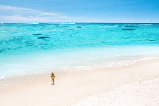 A little girl stands on Le Morne beach in the Indian Ocean on the island of Mauritius.