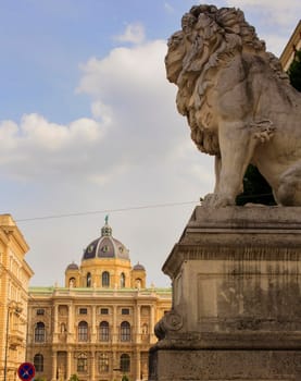 Lion statue in front of the Palace of Justice. In the background the Natural History Museum. Vienna