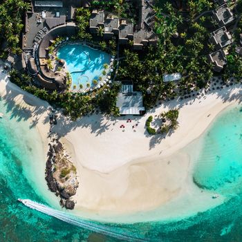 View from the height of the east coast of the island of Mauritius. Flying over the turquoise lagoon of the island of Mauritius in the area of Bel Mare